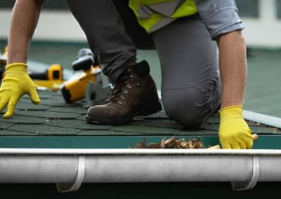 man worker is cleaning clogged roof